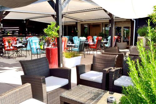 an outdoor patio with wicker chairs and tables and chairs at Hilton Strasbourg in Strasbourg