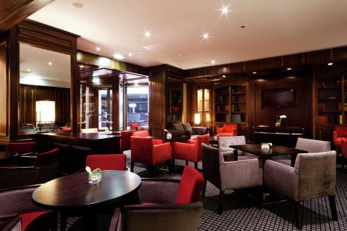 a restaurant with tables and chairs and a television at Hilton Strasbourg in Strasbourg