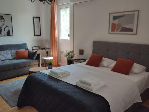 um quarto com uma cama grande e um sofá em Apartman studio MINNA Osijek, free parking em Osijek