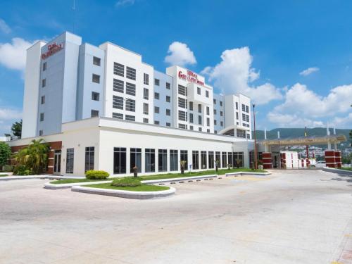 a large white building with a parking lot at Hilton Garden Inn Tuxtla Gutierrez in Tuxtla Gutiérrez