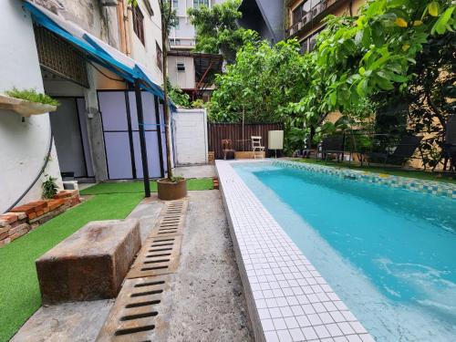 una piscina con césped junto a un edificio en The Manor by Mingle, en Kuala Lumpur