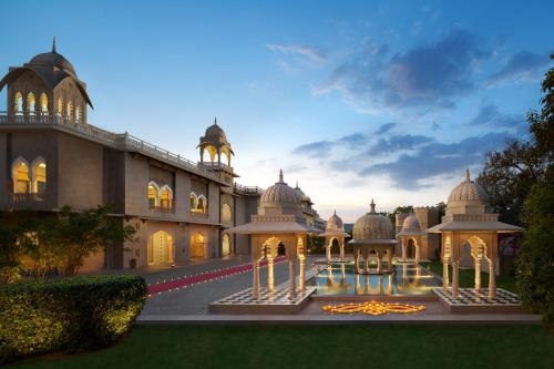 a building with a fountain in front of it at Fairmont Jaipur in Jaipur