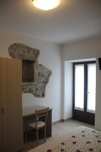 een slaapkamer met een bureau, een raam en een deur bij Agriturismo A' Taversa in Levanto