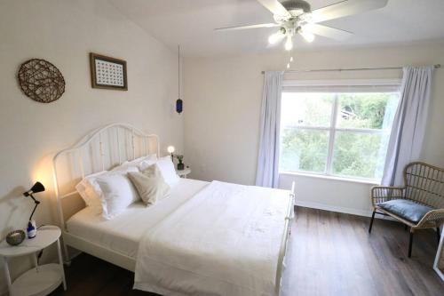 a bedroom with a white bed and a window at Stylish & Renovated Modern Farmhouse Boutique Apt in Gainesville