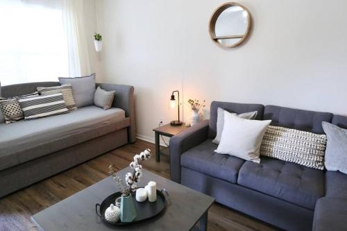 a living room with two couches and a table at Stylish & Renovated Modern Farmhouse Boutique Apt in Gainesville