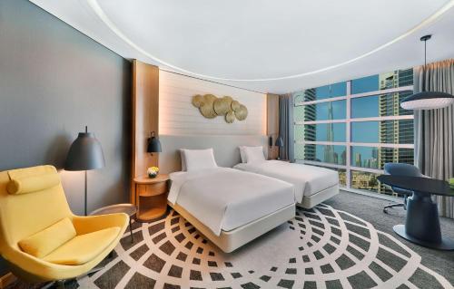 una camera d'albergo con due letti e una sedia di DoubleTree by Hilton Dubai - Business Bay a Dubai