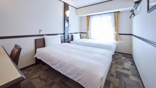 Tempat tidur dalam kamar di Toyoko Inn Narita Airport Shinkan