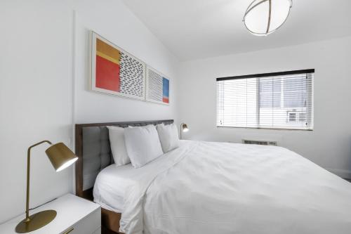 a white bedroom with a white bed and a window at Starlite Hotel in Miami Beach