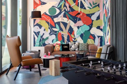 a living room with a giant chess board in front of a mural at Moxy Lisboa Oriente in Lisbon