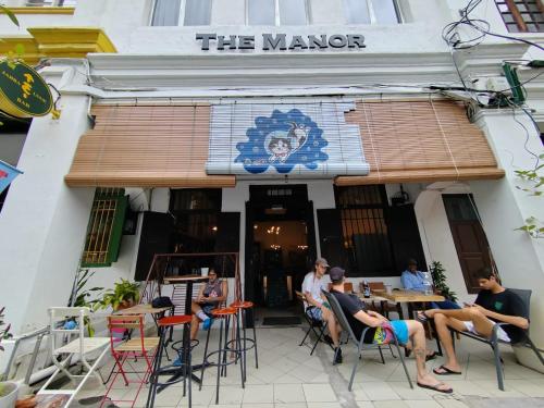 un grupo de personas sentadas en las mesas fuera de un restaurante en The Manor by Mingle, en Kuala Lumpur