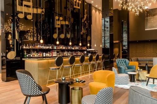 een bar met gele en blauwe stoelen en een bar bij Motel One Warsaw-Chopin in Warschau