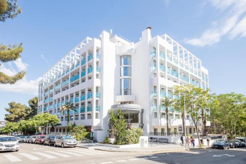 a white building with cars parked in a parking lot at Hotel Best Mediterraneo in Salou