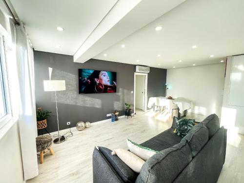 a living room with a couch and a flat screen tv at Airport Lisbon Guest House in Lisbon