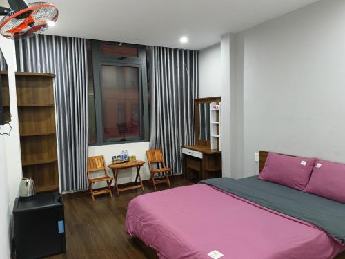 - une chambre avec un lit, une table et des chaises dans l'établissement Bơ House hotel, à Đà Lạt