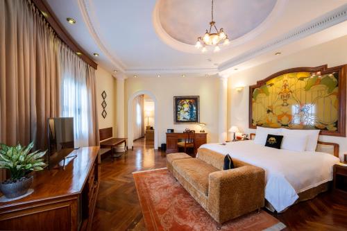 a hotel room with a bed and a couch at Hotel Majestic Saigon in Ho Chi Minh City