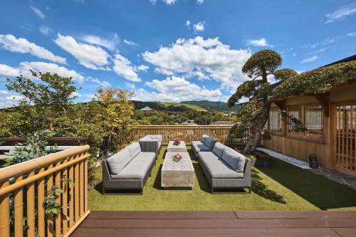 eine Terrasse mit Sofas und einem Tisch auf einer Terrasse in der Unterkunft Hotel New Wakasa in Nara