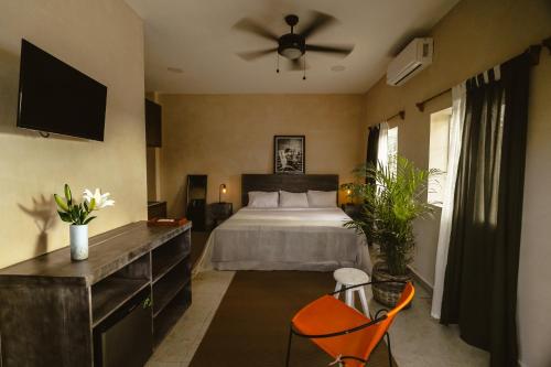 1 dormitorio con 1 cama y ventilador de techo en Gardenia Collective, en Tulum