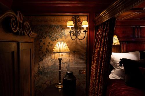 a bedroom with a bed and a lamp on a wall at The Witchery by the Castle in Edinburgh