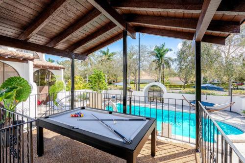 a pool table on a balcony next to a swimming pool at Villa at St James Unit A Luxury Pool Villa, Pet Friendly in Miami