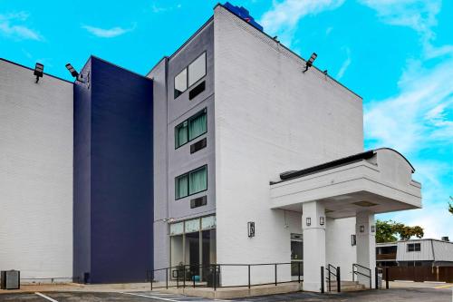 a white building with a blue sky in the background at Motel 6 Arlington TX Entertainment District in Arlington