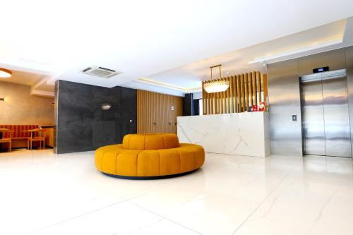 a large lobby with a yellow ottoman in the middle at Riva Hotel Alsancak in İzmir