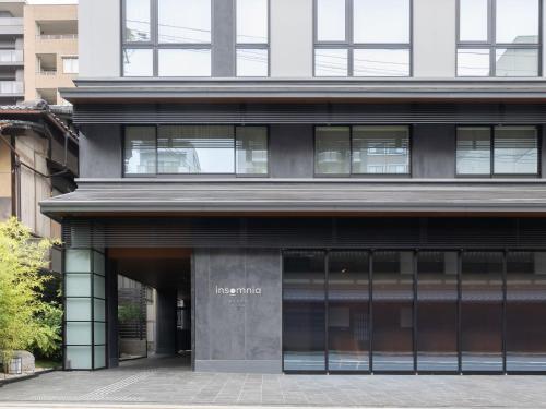 a large building with glass windows on the side of it at insomnia KYOTO OIKE in Kyoto