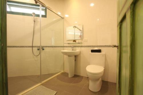 a bathroom with a toilet and a shower and a sink at 皇裔民宿 - 歐式小屋 in Hualien City