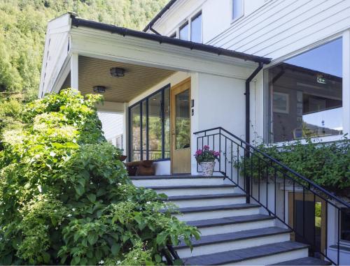 une maison avec un escalier menant à la porte d'entrée. dans l'établissement Heimly Pensjonat, à Flåm