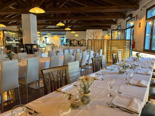 a dining room with long tables and white chairs at Aquasole in Mercallo