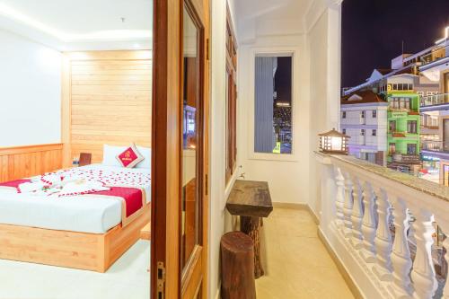 Cette chambre d'hôtel comprend un lit et un balcon. dans l'établissement Ngọc Sang 1 Hotel, à Đà Lạt