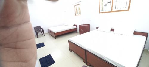 um quarto com duas camas e uma cadeira em Mahadev Home Stay em Varanasi