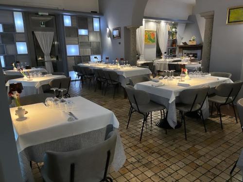 CanzoVilla Nasti Hotel Ristorante的配有桌椅和白色桌布的房间