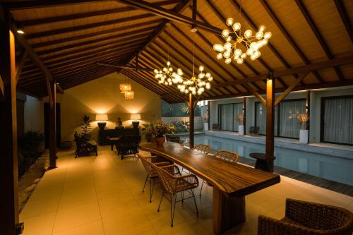 een patio met een grote houten tafel en stoelen bij Luna Ola Villa Berawa in Canggu