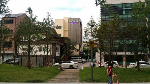 a person walking down a sidewalk in a city at Parkavenue Guesthouse in Seoul