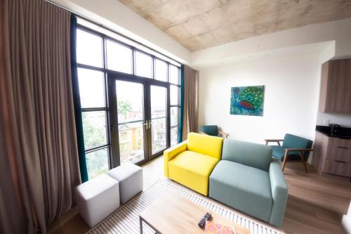 a living room with a yellow couch and large windows at The Laundry Rooms Augusta in Hamilton