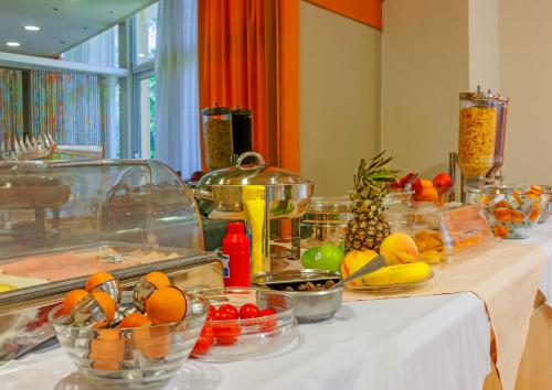 una mesa con tazones de frutas y hortalizas. en Park Hotel, en Atenas