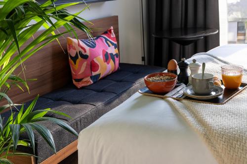 a table with a tray of food on a bed at Les Artistes in Paris