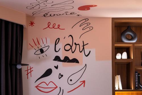 a wall with drawings on it in a room at Les Artistes in Paris