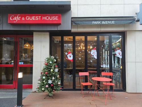 a christmas tree in front of a cafe and guest house at Parkavenue Guesthouse in Seoul