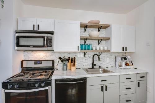 a white kitchen with a stove and a microwave at Atlantic City Home about 2 Mi to Ocean Casino Resort! in Atlantic City