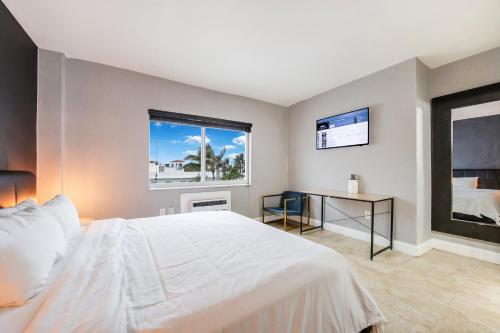 a bedroom with a large white bed and a window at Starlite Hotel in Miami Beach