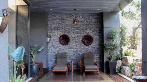 a patio with a table and chairs and a brick wall at Einhan Resort in Yuchi