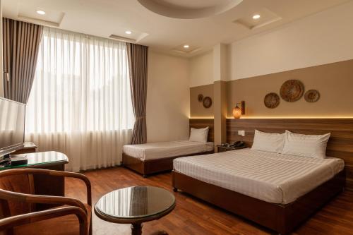 a hotel room with a bed and a table at Lantern Hotel in Ho Chi Minh City