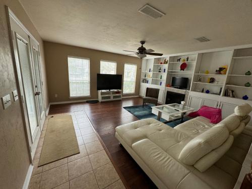 a living room with a white couch and a tv at A stylish and Comfy Place to Stay in Gainesville