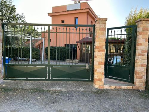 a green gate with a brick building behind it at T'Addormento in Reggio di Calabria