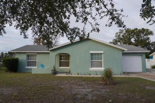 uma casa verde com uma garagem branca em House of Blues-3 Bedrooms+GameRoom em Orlando