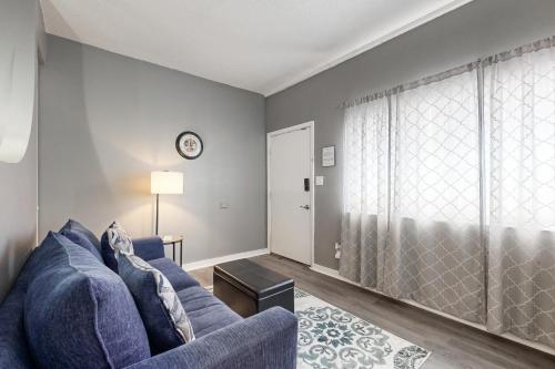 a living room with a blue couch and a window at Okaloosa Island Studio in Fort Walton Beach