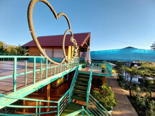 a building with green stairs and two ropes at K'Ho Cil Homestay Tà Nung in Da Lat