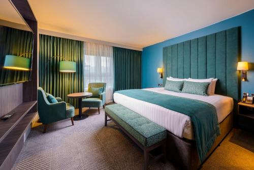 um quarto de hotel com uma cama grande e cadeiras em Hotel Killarney em Killarney