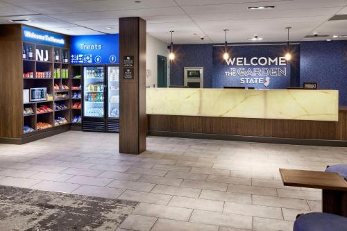 een winkel lobby met een welkom op de tuin staat bord bij Hampton Inn Newark Airport in Newark